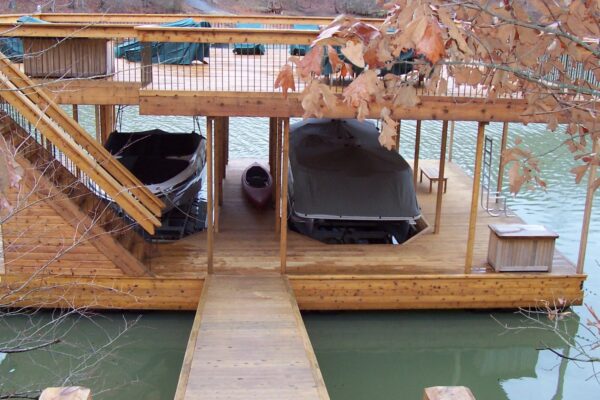 A dock with two covered boat parking spaces, nestled in a scenic waterfront setting.