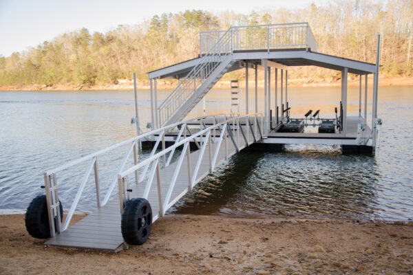 A waterfront scene featuring a dock with an attached bridge and a boat lifter for seamless marine access.