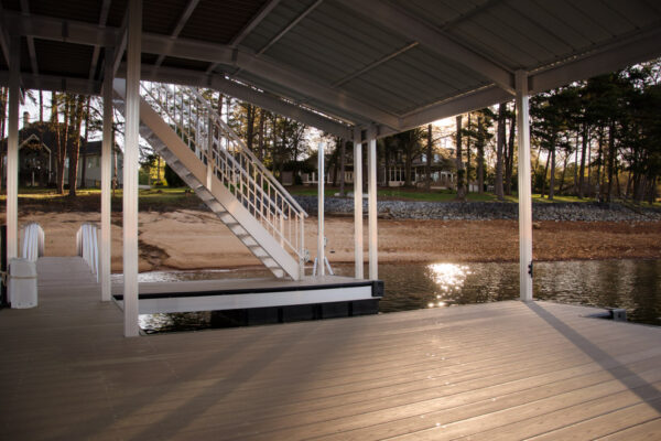 A dock with a single boat parked, set against a scenic waterfront backdrop.