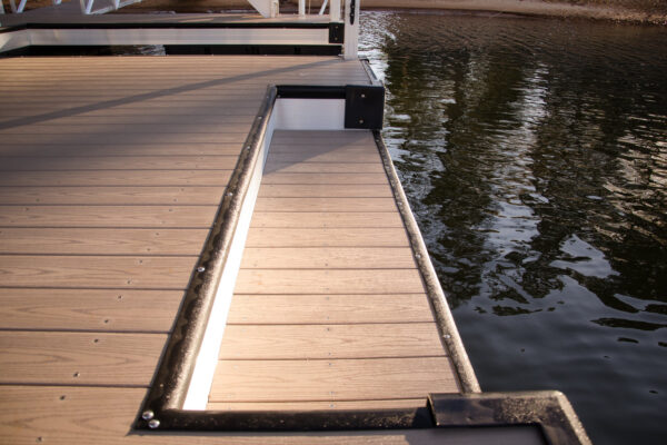 Close-up of a dock floor with footstep imprints, showcasing textured wood planks.