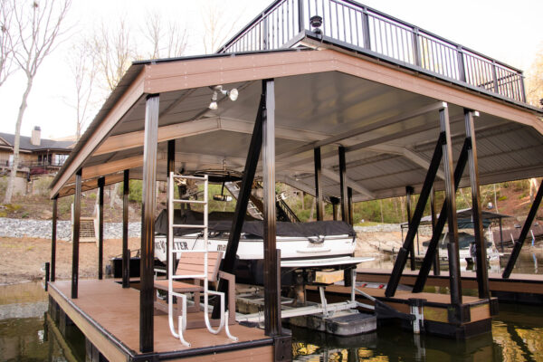 A dock with two boat parking spaces, one currently occupied, against a picturesque waterfront backdrop.