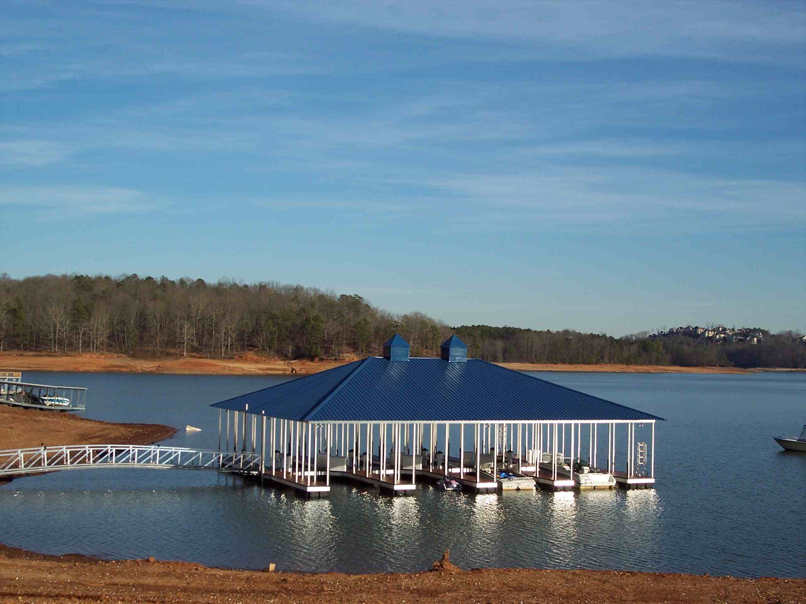 A dock with capacity for five boats, featuring a stylish blue hip roof and a pathway elevated above the water